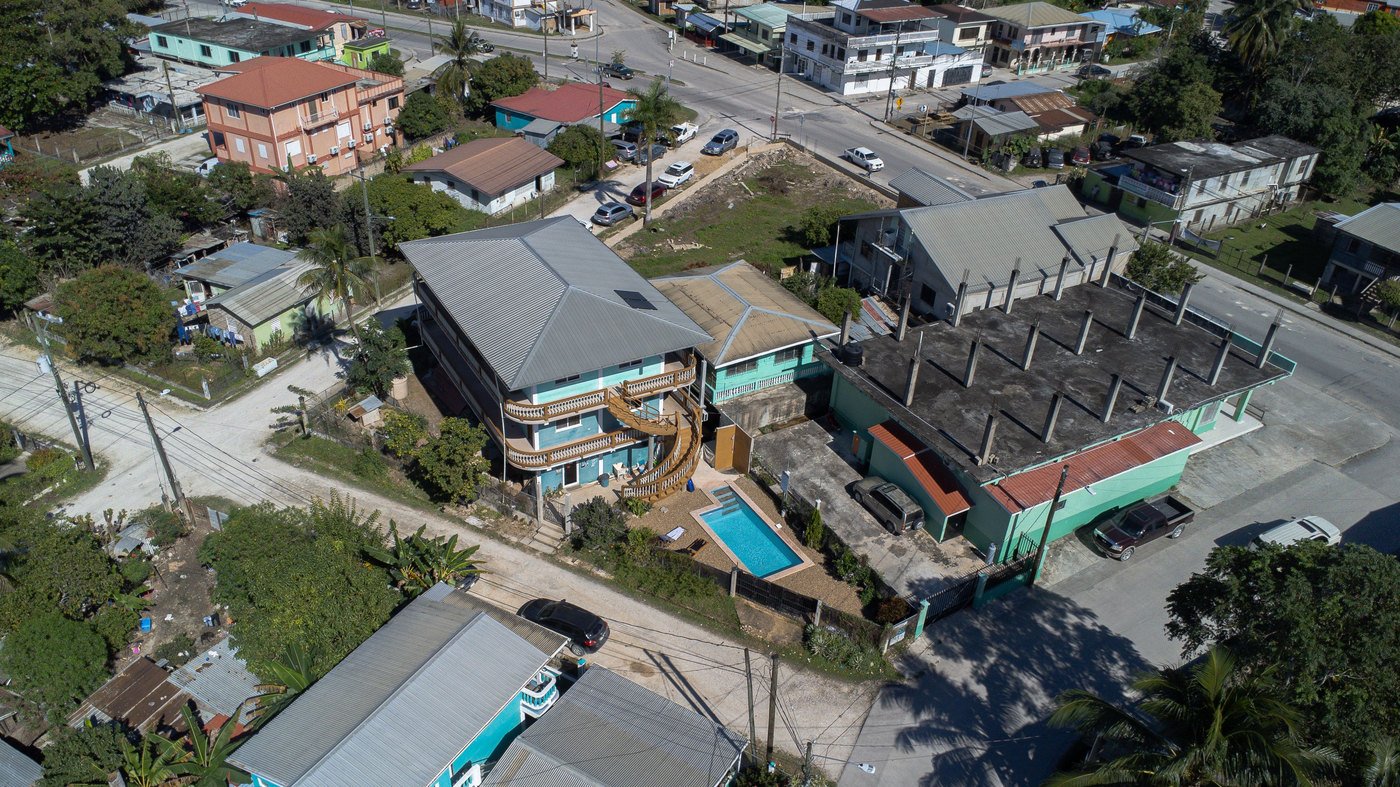 Aerial view of Hilltop Horizon Guesthouse, its curved wooden staircase, and outdoor pool.